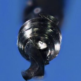 Recovered screw fragment on the .8mm custom drill: note the concentricity away from the threads as the drill tip exited the screw end Recovered screw fragment on the .8mm custom drill: note the concentricity away from the threads as the drill tip exited the screw end