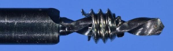 Recovered screw fragment on the .8mm custom drill: note the concentricity away from the threads as the drill tip exited the screw end Recovered screw fragment on the .8mm custom drill: note the concentricity away from the threads as the drill tip exited the screw end